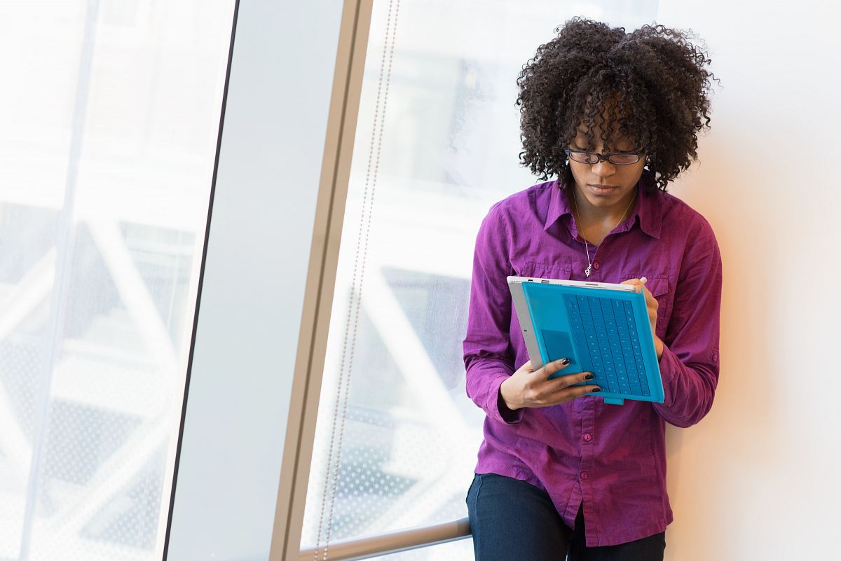 woman in purple dress shirt using laptop